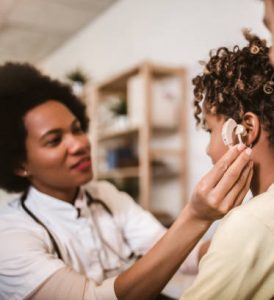 Smiling deaf girl learning sign language at doctor's office